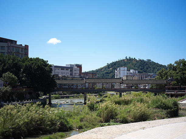 istock Urban River Landscape with Mountain View and Traditional Covered Bridge 2240064401