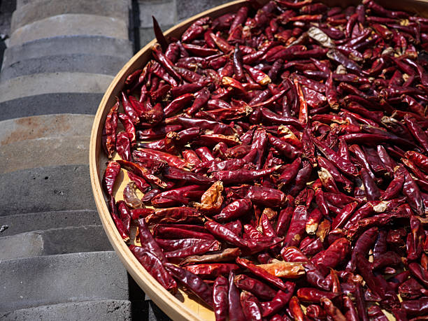 istock Dried Red Chilies Spread Out on a Wooden Tray for Sun Drying 2240064681