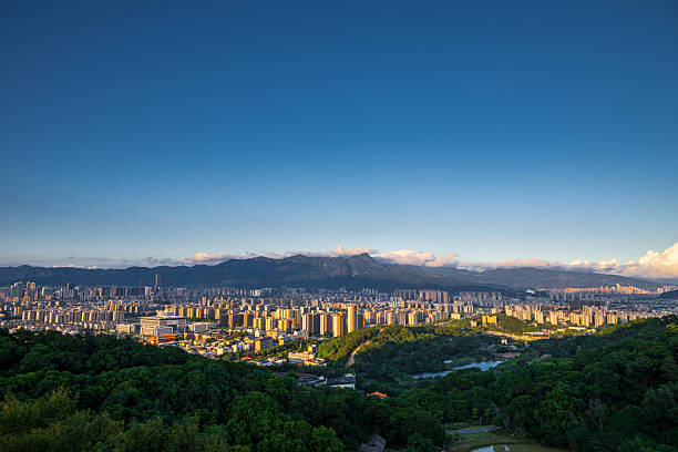 A Panoramic View of the City Blending with Forested Hills at Dusk