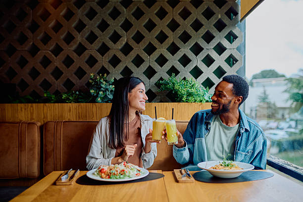 istock Happy couple toasting drinks enjoying restaurant date 2240068037