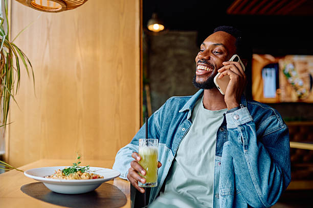 istock Smiling man talking on phone during lunch 2240068999