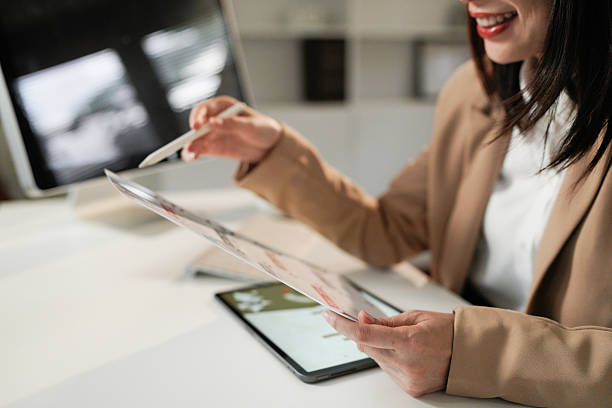 istock Business asian woman reading document paper on working table at office 2240069050