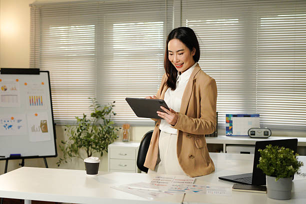 istock Business asian woman using business application on tablet for project management, working on Internet marketing strategy, typing on screen, browsing social media on digital gadget 2240069158
