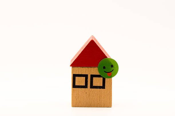 A cute little miniature house placed by a window where light shines in