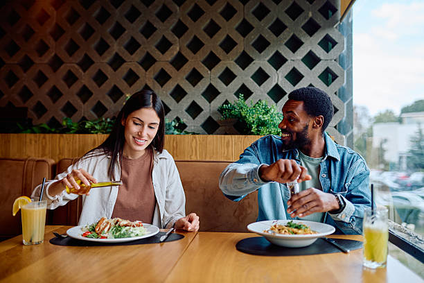 istock Diverse couple enjoying lunch in modern restaurant 2240069242