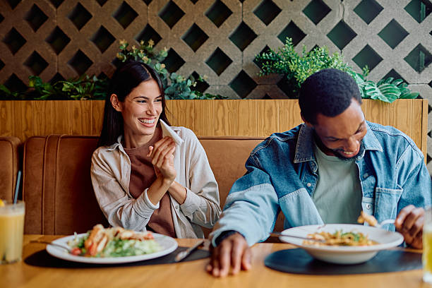 istock Diverse couple laughing enjoying a meal together 2240069291
