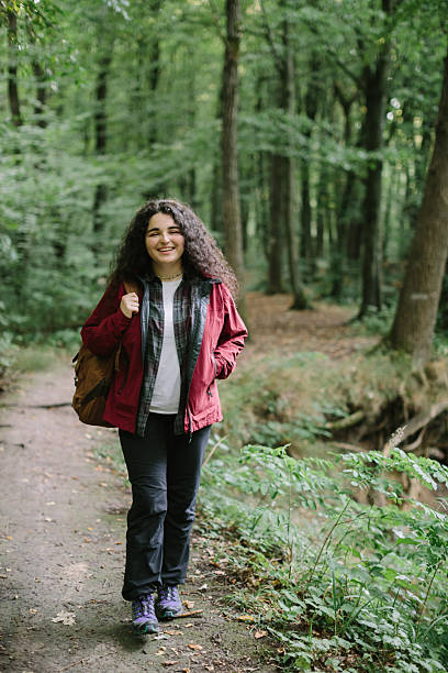 istock Young woman hiking forest path enjoying nature 2240070078