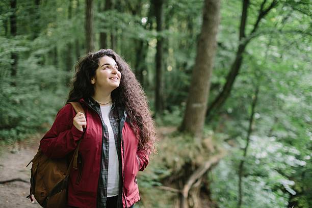 istock Young woman hiking in green forest smiling 2240070099