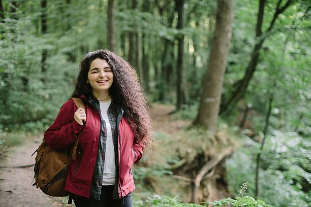 istock Young woman smiling enjoying forest hike 2240070101
