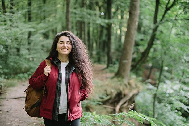 istock Young woman smiling enjoying forest hike 2240070103