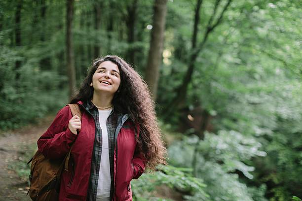 istock Young woman enjoying forest hike with backpack 2240070107