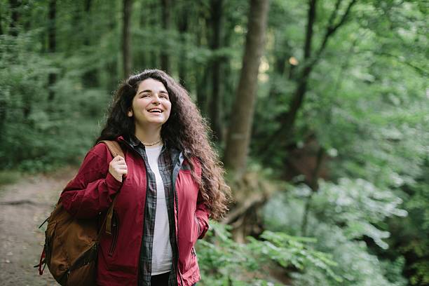 istock Young woman enjoying hike in lush green forest 2240070108
