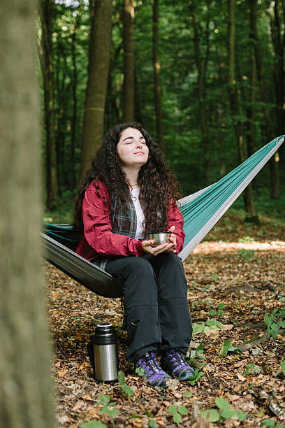 istock Young woman relaxing in hammock enjoying forest nature 2240070146