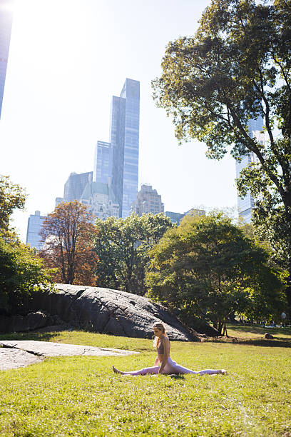 istock Woman doing yoga splits stretching in central park 2240070315