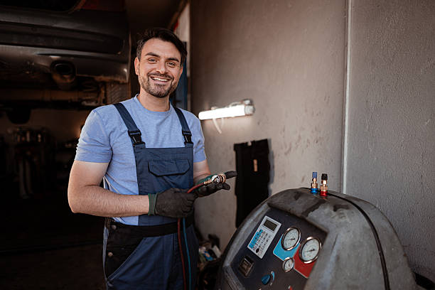 istock Mechanic working on car maintenance in a garage, smiling and using tools in daylight 2240070440
