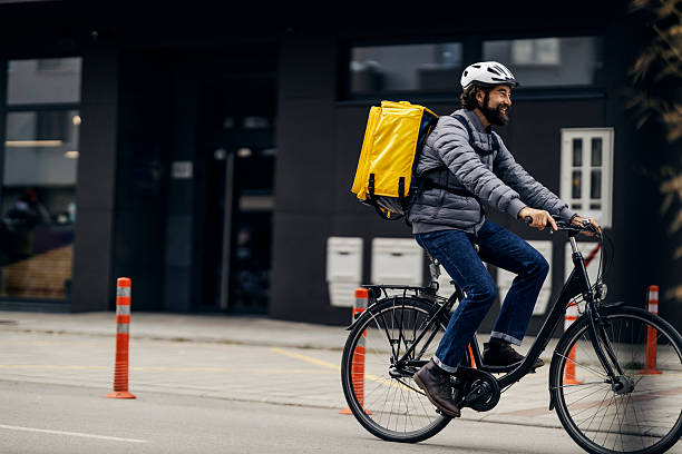 istock Man courier delivering food by bicycle in city 2240070911