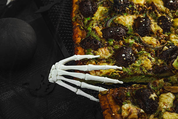 Spooky homemade pizza with green dough, mushroom skulls, and melted cheese. Halloween dark food