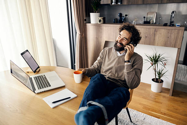istock Happy man talking on smartphone working from home 2240072157