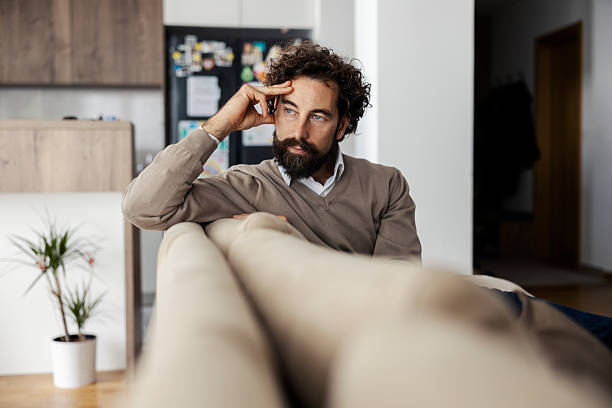 istock Man thinking on couch at home, deep in contemplation 2240072243