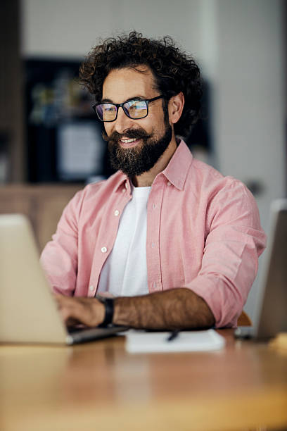 istock Man working on laptop and smiling in home office 2240072496