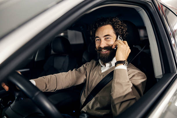 istock Man driving car and talking on mobile phone 2240072740