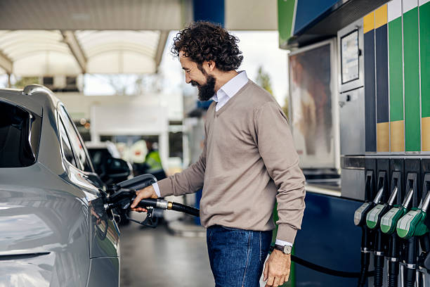 istock Man refueling car at gas station looking happy 2240072930