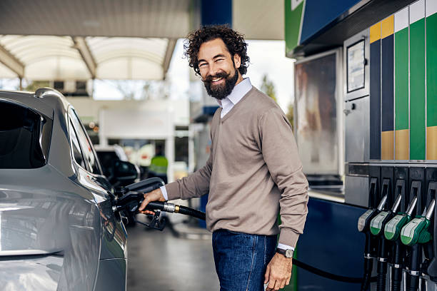 istock Man smiling while refueling car at gas station pump 2240072946
