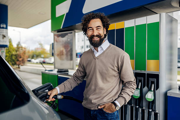 istock Man smiling refueling car at a gas station 2240072965