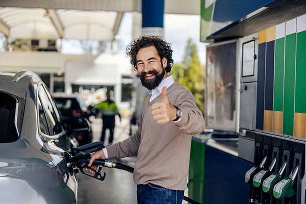istock Man giving thumbs up while refueling car at gas station 2240072976