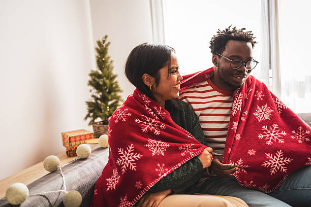 istock Diverse couple relaxing under christmas blanket during holidays 2240073178