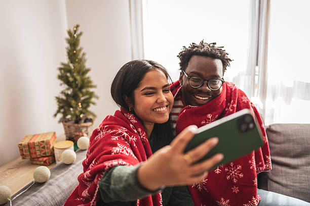 istock Loving couple taking christmas selfie on cozy sofa 2240073195