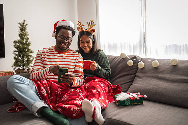istock Couple celebrating christmas at home using smartphone 2240073214