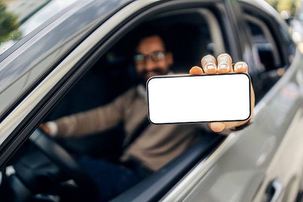 istock Man showing smartphone screen from car window 2240073358