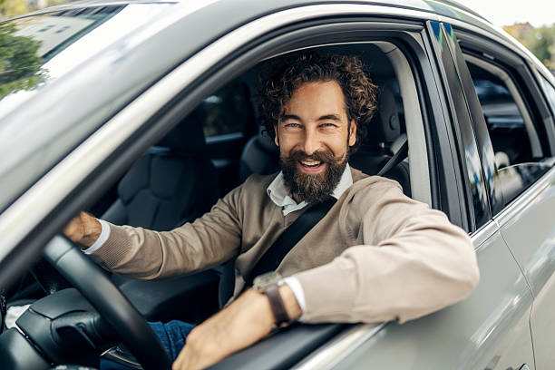 istock Happy man driving car looking confident and smiling 2240073445