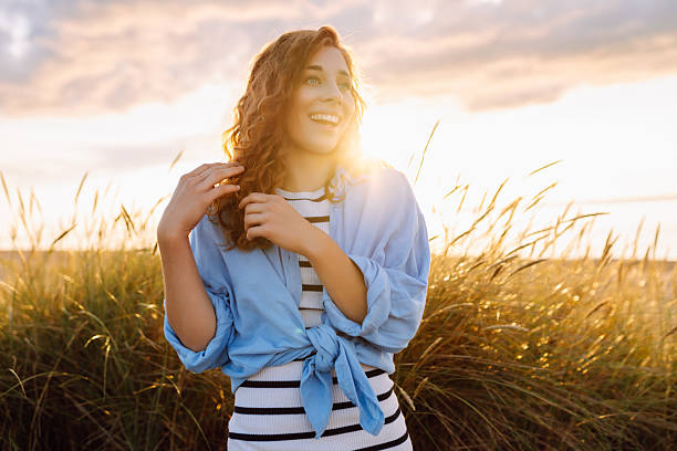 istock A young woman strolls along the beach on a sunny day. 2240073501