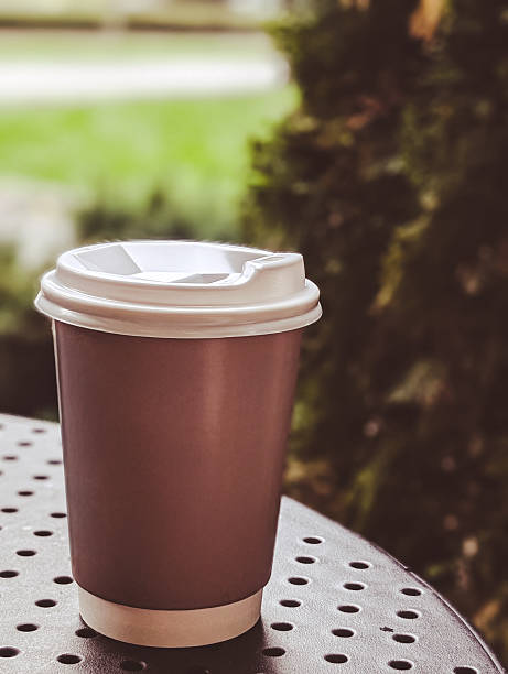 istock blank paper coffee cup on a perforated metal cafe table outdoors 2240073876
