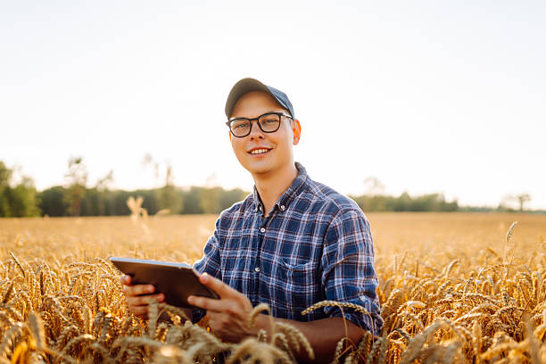 istock A young farmer in a checkered shirt with a digital tablet works in a field. 2240074056