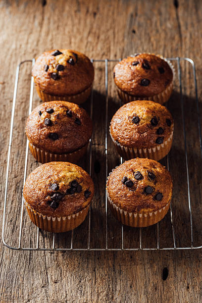 istock Freshly Baked Chocolate Chip Muffins on Wooden Table Surface 2240075010