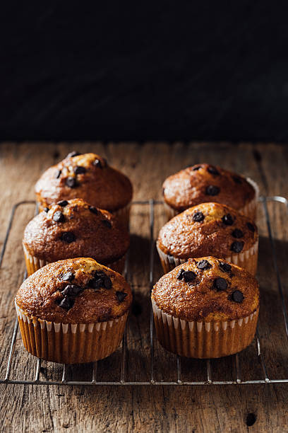 istock Freshly Baked Muffins with Chocolate Chips on Rustic Wooden Table 2240075102