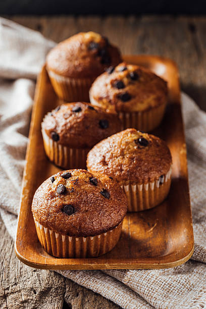 istock Freshly Baked Muffins with Chocolate Chips on Wooden Tray 2240075756