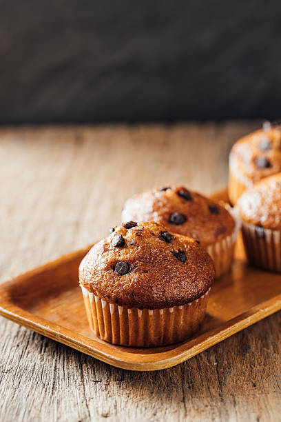 istock Delicious Chocolate Chip Muffins on Wooden Tray with Rustic Background 2240075784
