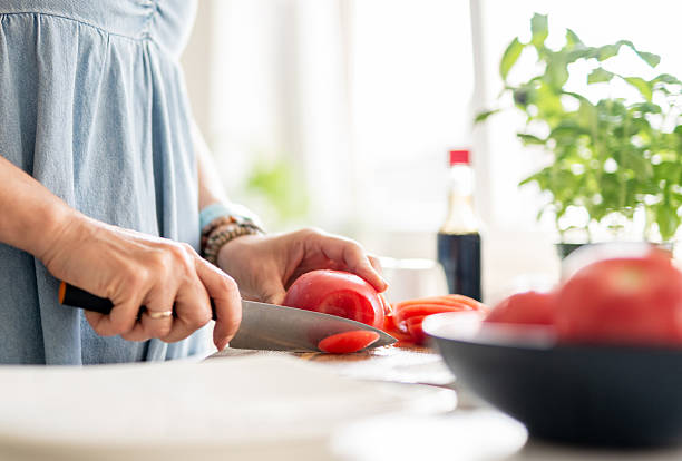 istock Women'S Hands Are Slicing Tomato 2240077056
