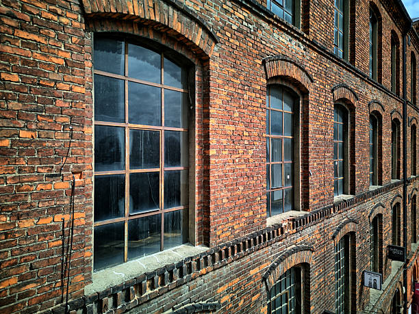 Industrial brick facade, dramatic dark HDR, large windows, diagonal composition, urban texture, evening mood, Lodz, Poland, horizontal aerial