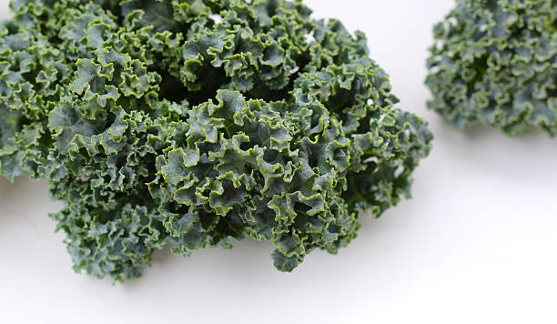 istock Fresh curly kale leaves with textured green surface. 2240079039