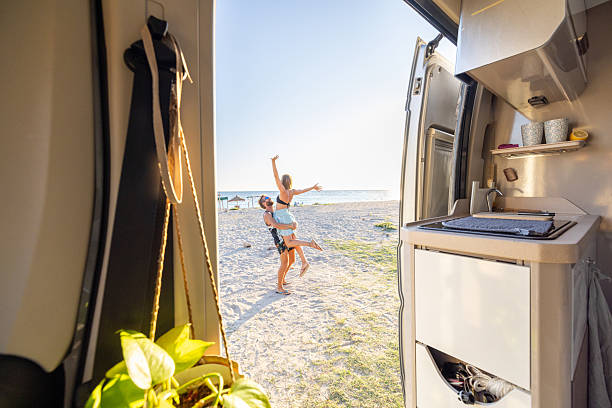 istock Couple Embracing Outside Camper Van at Beach 2240079298