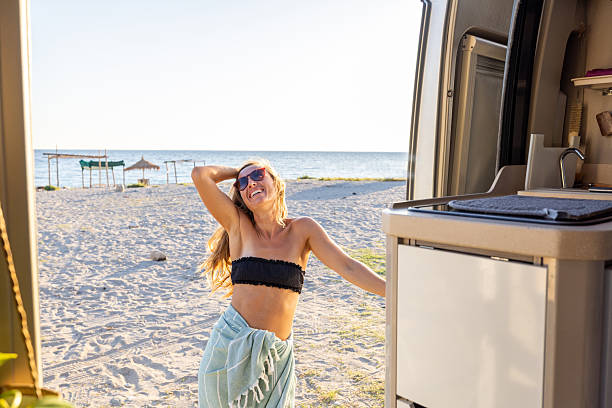 istock Woman Walking on Beach Near Camper Van 2240079975