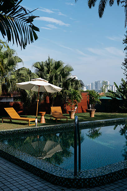 istock Tranquil Poolside Scene with Lounge Chairs and Umbrella 2240080416