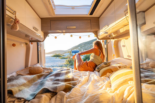 istock Woman Relaxing Inside Camper Van at Sunset 2240080449