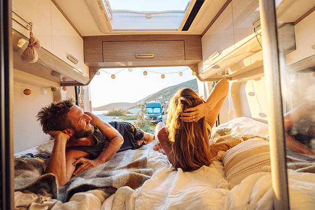 istock Cozy Couple Watching Sunset from Camper Van 2240080498