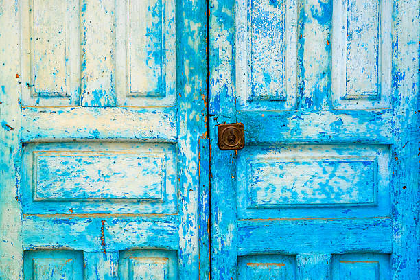 An old blue door that has been weathered and textured by the sun over the years.